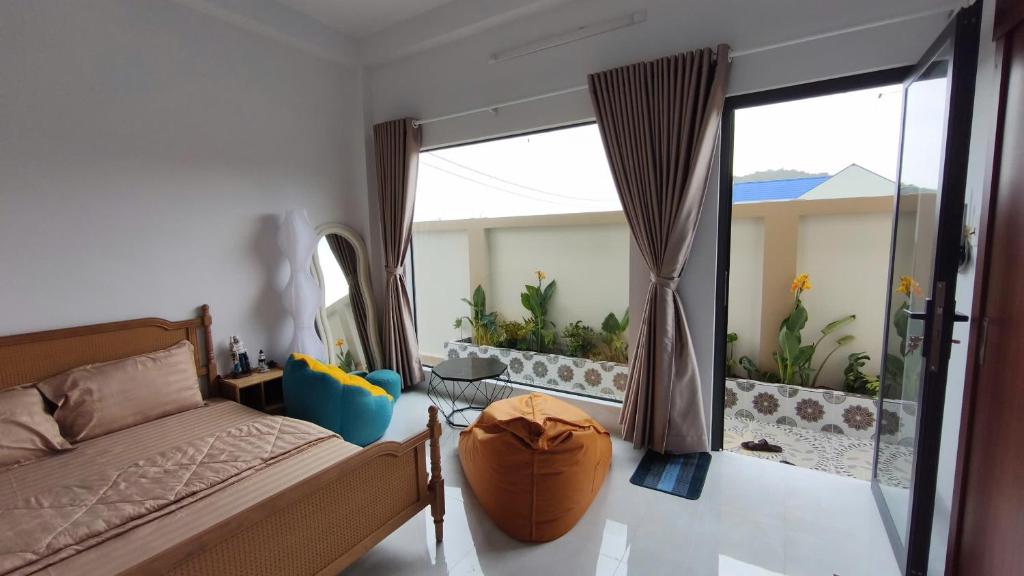 a bedroom with a bed and a large glass window at Mango Homestay Hà Tiên in Hà Tiên