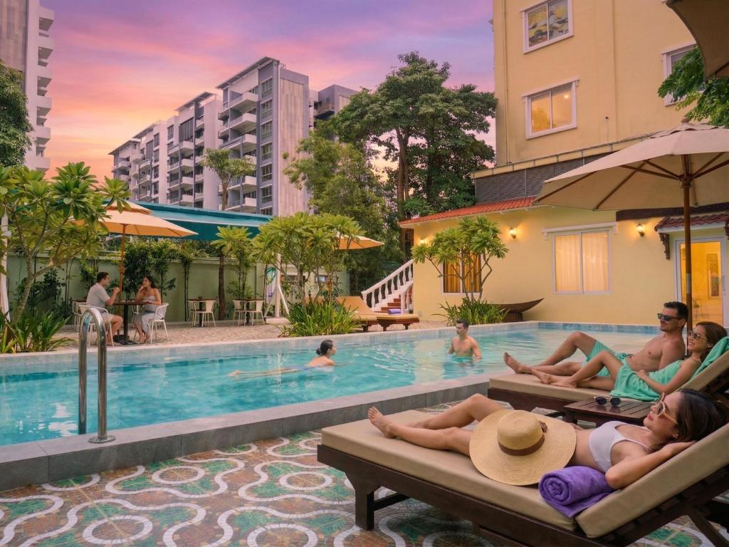 a group of people sitting in the swimming pool at a hotel at Le Kree Downtown Hotel in Phnom Penh