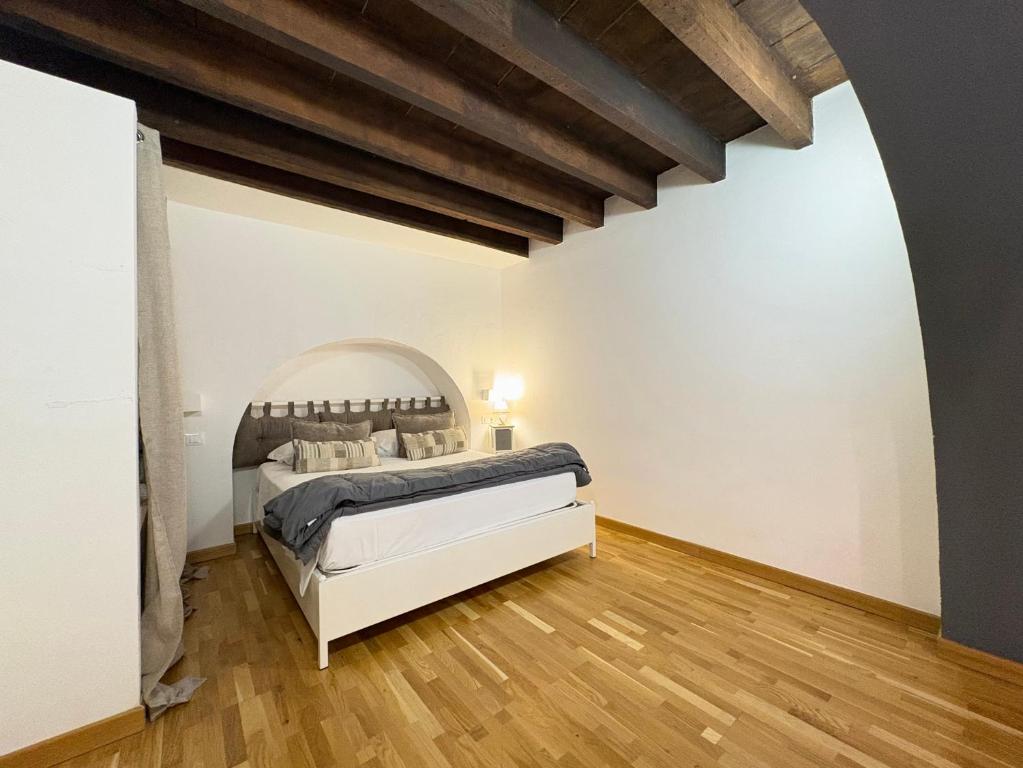 a bedroom with a bed and a wooden floor at Loft Nineteen Apartment in La Spezia