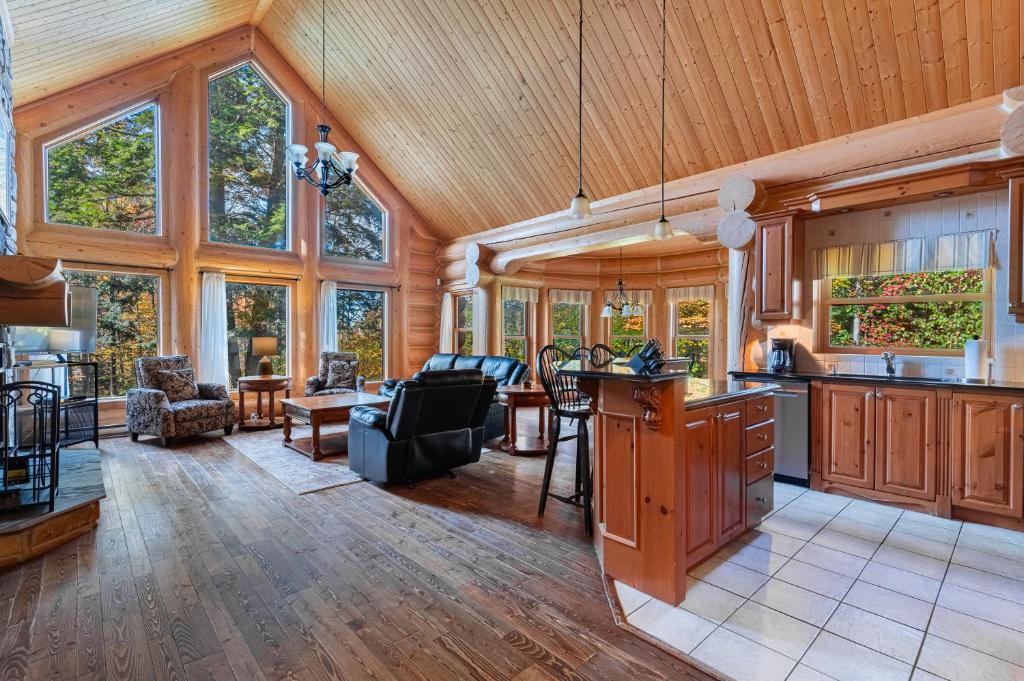 a kitchen and living room in a log cabin at Fiddler Lake Resort - Rabbit 12 in Mille-Isles