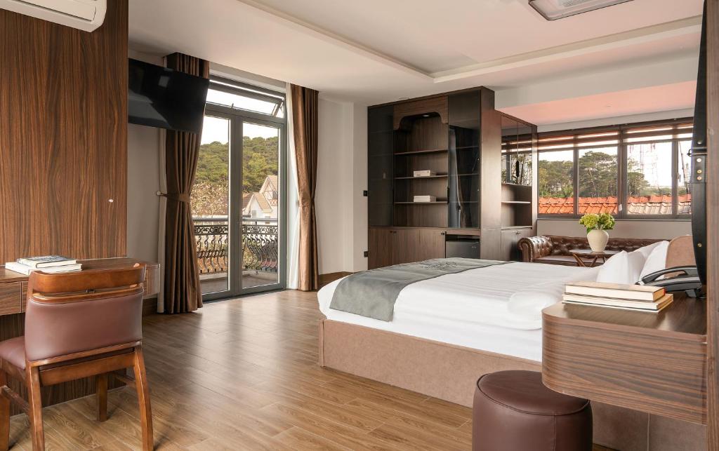 a hotel room with a bed and a desk and a desk at Khách sạn Brume Đà Lạt in Da Lat