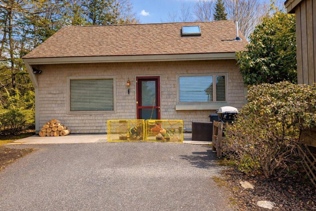 a house with a gate in front of it at Cozy Coastal Hideaway with Harbor Views in Tremont
