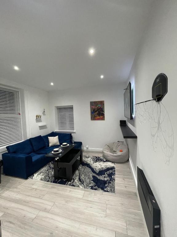 a living room with a blue couch and a tv at Stylish 2BR Duplex - Central & Spacious in Sunderland