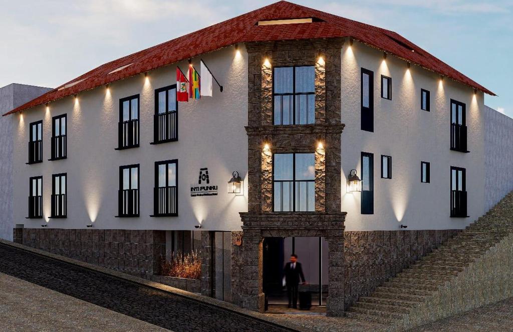 a man standing in front of a building with lights at Inti Punku Cusco - Centro Histórico Hotel in Cusco