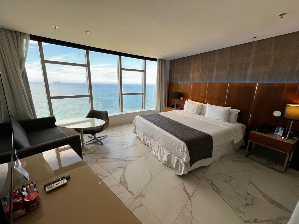 a hotel room with a bed and a couch and a desk at Hotel Nacional in Rio de Janeiro
