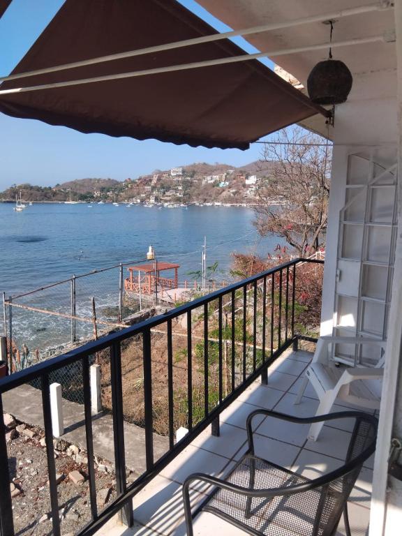 a balcony with a view of the water at Bungalow Encanto in Zihuatanejo
