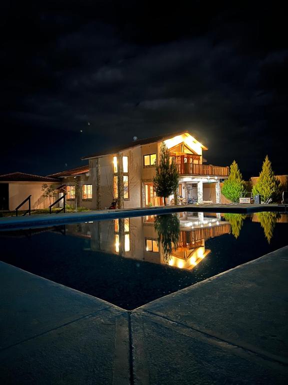 a large house with a swimming pool at night at Cabaña con Piscina para Descansar in Chihuahua