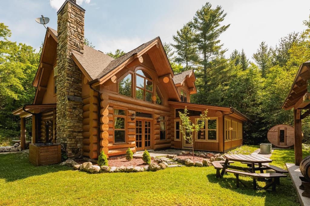 a log cabin with a picnic table in the yard at Fiddler Lake Resort - Bear 14 in Mille-Isles