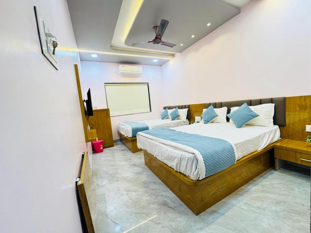 a bedroom with two beds and a projection screen at Sairam Residency in Ellora