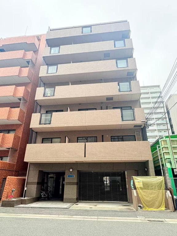 a tall building with a parking garage in front of it at カリエンテ三宮202 in Kobe