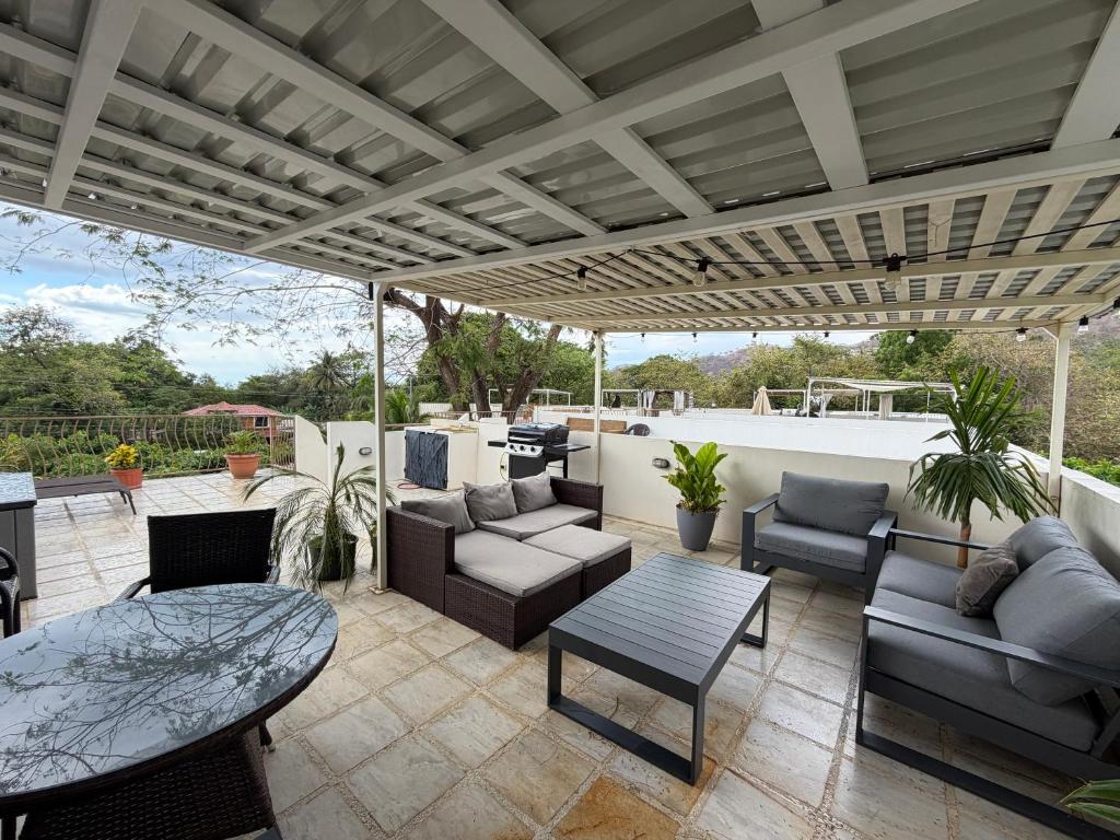 a patio with couches and chairs and a table at Charming condo with a rooftop, across beach in Coco