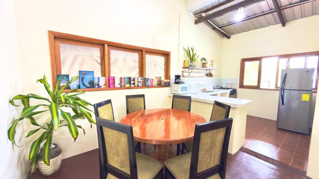 a kitchen with a wooden table and chairs and a refrigerator at Casa independiente in Puerto Ayora