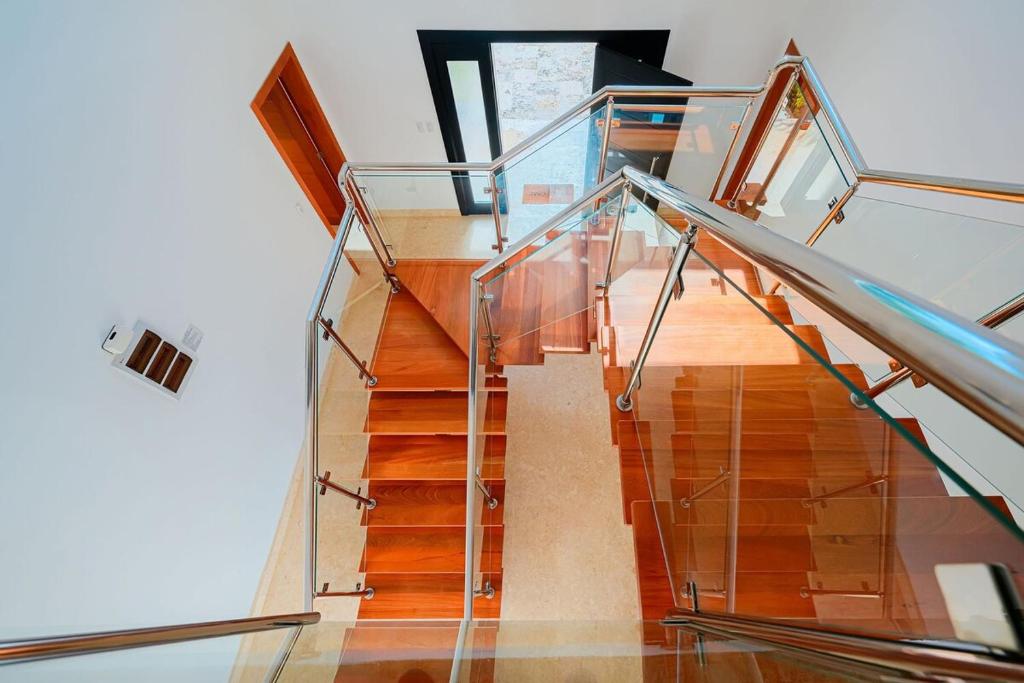a staircase with a glass railing and wooden floors at Villa 107 in Sosúa