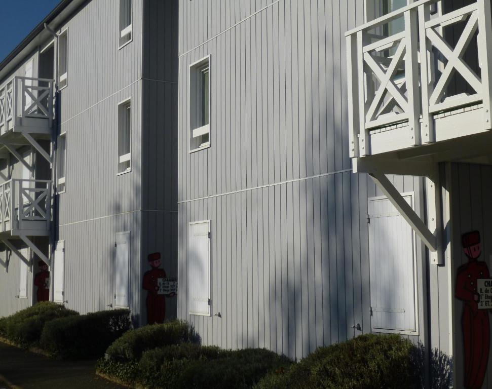 a large white building with two garage doors on it at Fasthotel Angers Beaucouzé in Beaucouzé