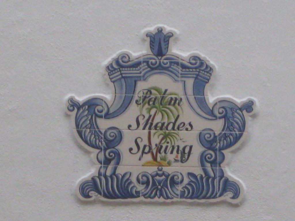 a blue and white sign on a white wall at Palm Shades Spring in Benaulim