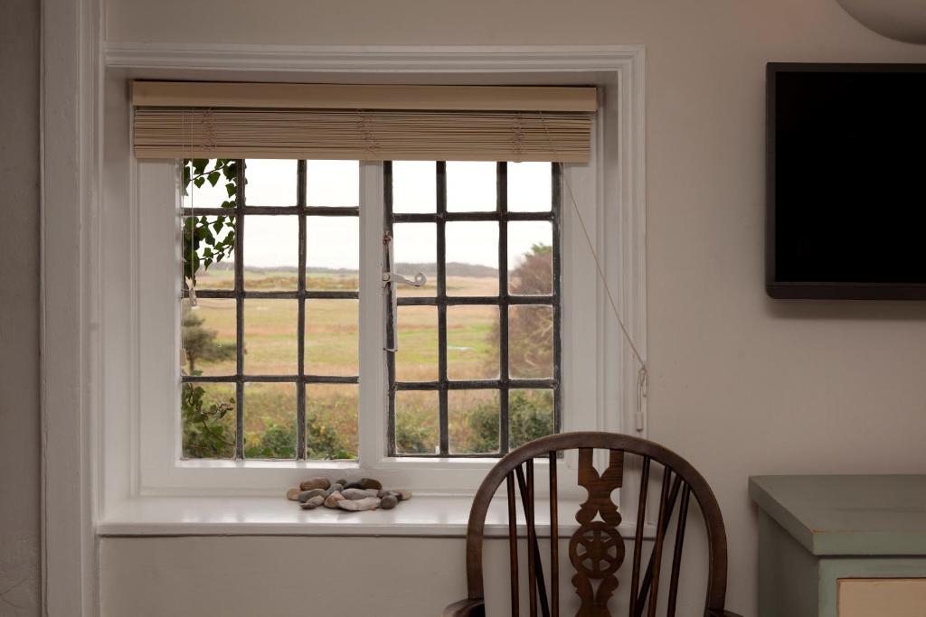 a window with a view of a field at The Ship At Dunwich in Dunwich