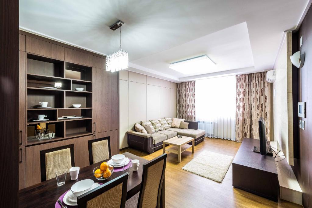 a living room with a couch and a dining room at The Address Highvill 2 in Astana