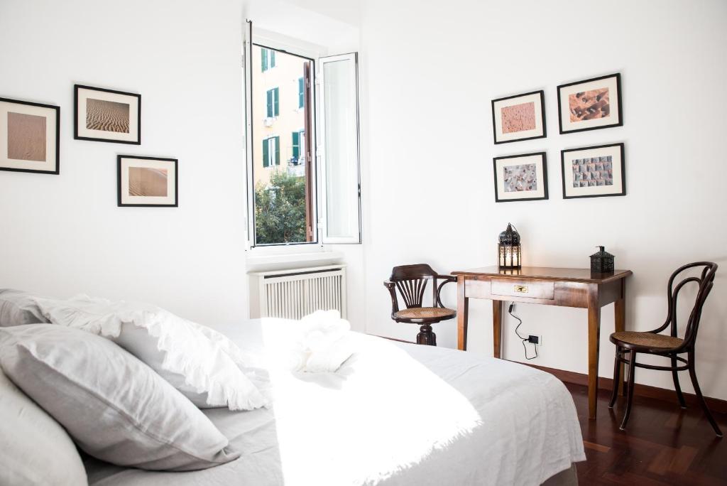 1 dormitorio con cama, escritorio y ventana en Porta Latina Apartment en Roma