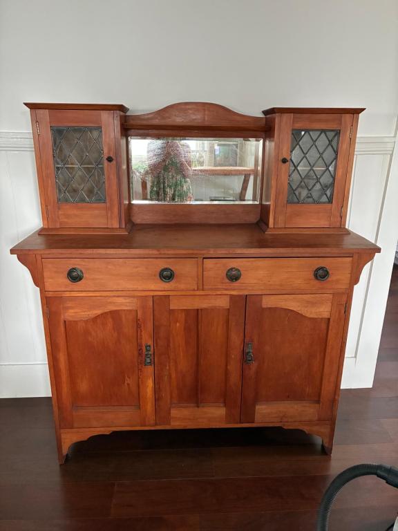 a wooden cabinet with a mirror on top of it at Timeless Villa on Parore in Dargaville