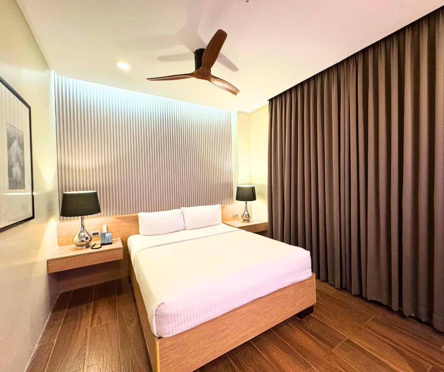ein Schlafzimmer mit Bett und Deckenventilator in der Unterkunft Lenox Hotel in Dagupan
