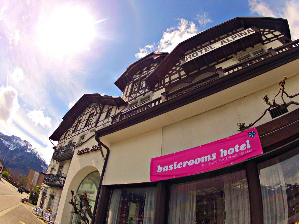 un edificio con una señal rosa en el costado. en BasicRooms Hotel en Interlaken