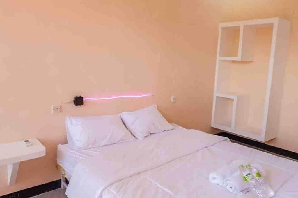 a small bedroom with a white bed and a sink at Artayya Puri 2 near Alun Alun Caruban Mitra RedDoorz in Madiun