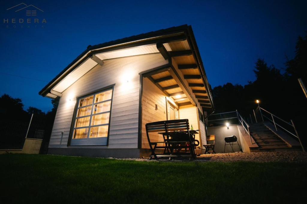 ein kleines Haus mit einer Veranda bei Nacht in der Unterkunft Hedera Sovata in Sovata