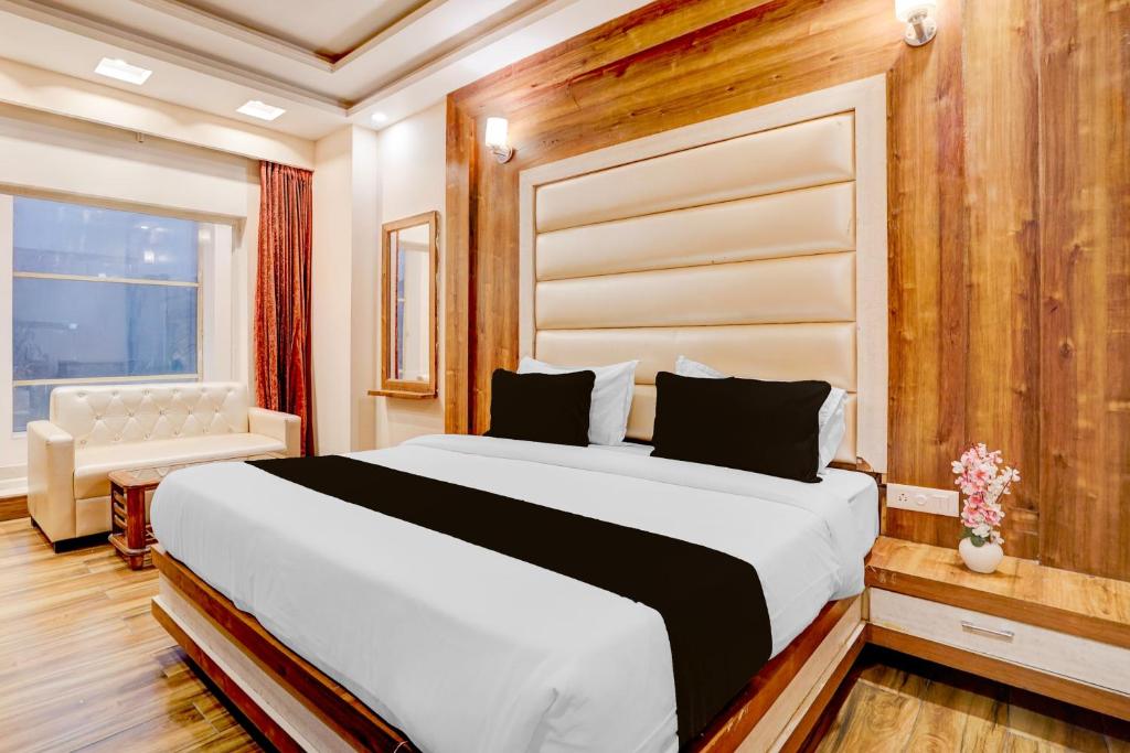 a bedroom with a large white bed and a window at Townhouse Oak Dehradun Court Formerly GK Residency in Dehradun