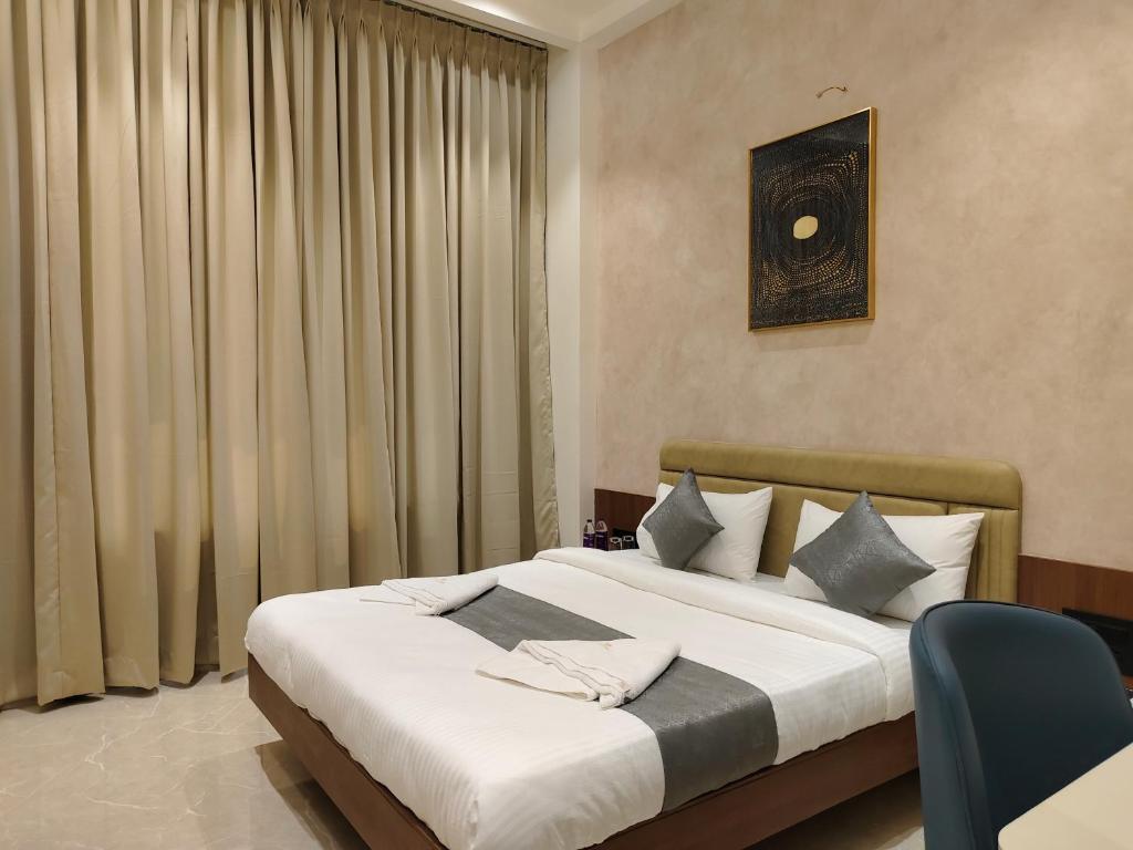 a bedroom with a bed with white sheets and pillows at Hotel Raas Vrindavan in Laling