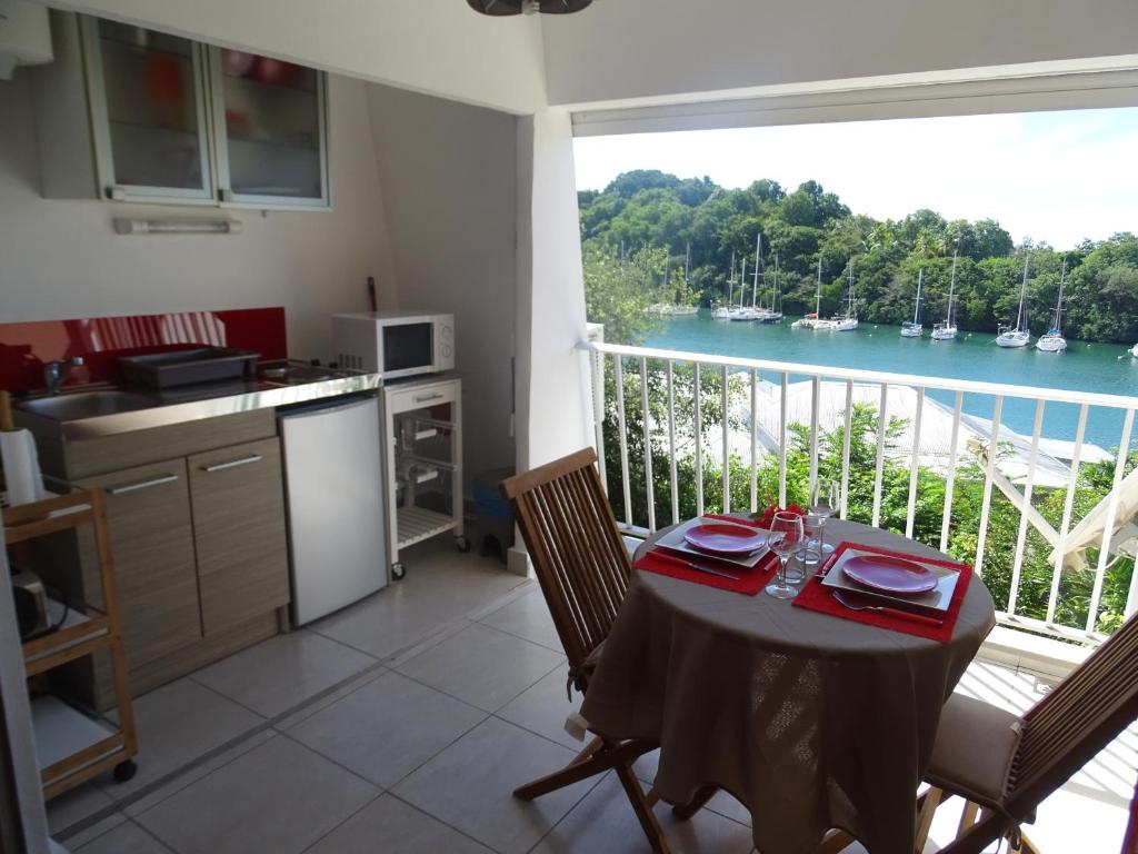 a kitchen with a table and a view of the water at Charmant Studio Vue Mer Village Soleil in Le Gosier