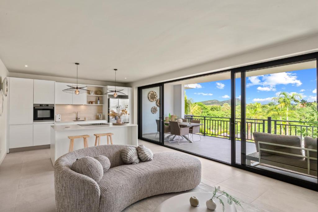 a living room with a couch and a kitchen at Luxury Two-Bedroom Apartments at Blue Bay The Breeze in Dorp Sint Michiel