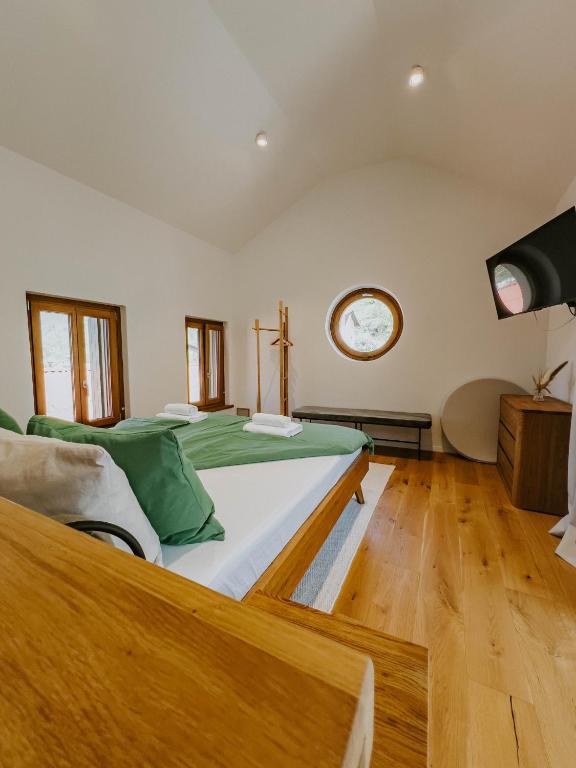 a large bed in a room with a clock on the wall at Up and above in Kobarid