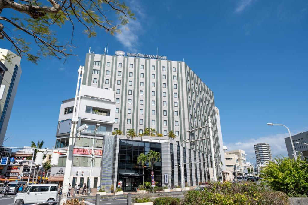 a tall white building with a sign on top of it at Hotel Monterey La Soeur Naha in Naha