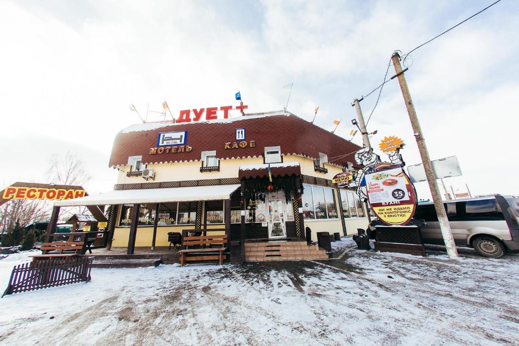 un restaurante en la nieve frente a un edificio en Duet Plus Motel, en Voytovtsy