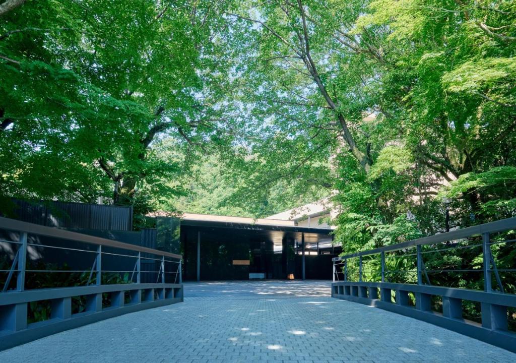 a bridge in a park with trees and a building at Fufu Atami in Atami
