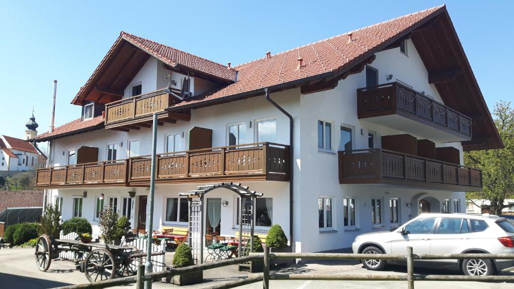 een gebouw waar een auto voor geparkeerd staat bij Gasthof "Zum Strauß" in Wildsteig