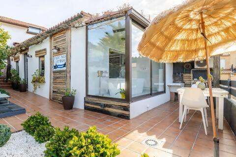 a patio with a table and an umbrella at Mar no Camiño. Terraza, bañera con vista al mar. in Brens