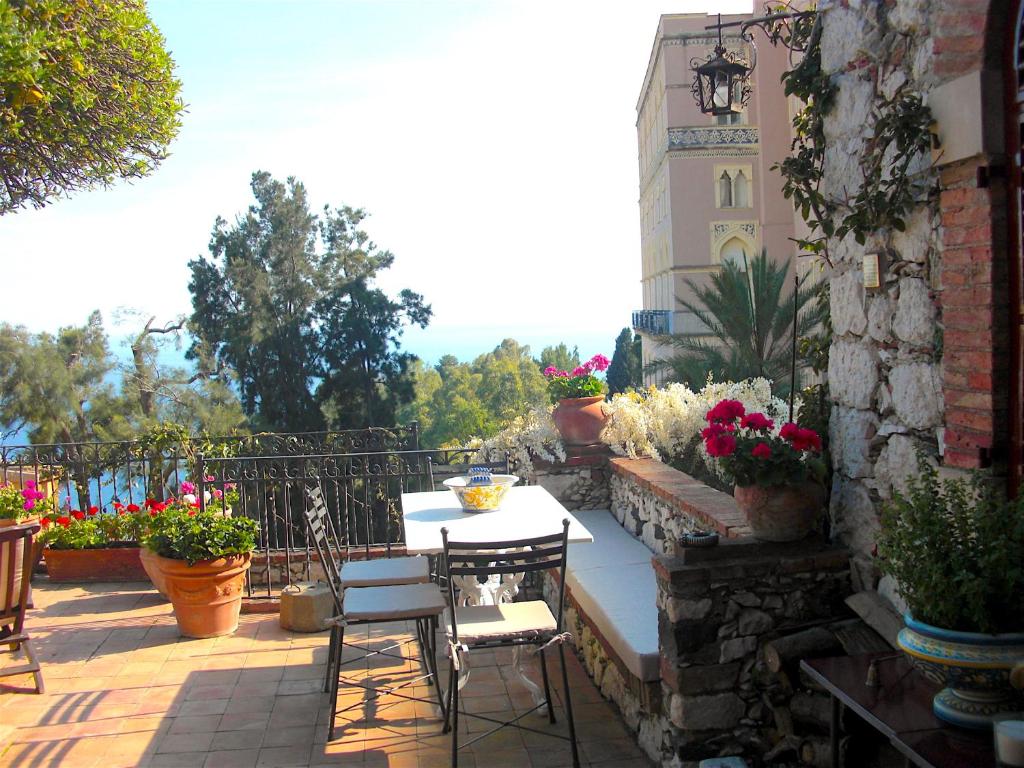 a patio with a table and chairs and flowers at Casa Oasi in Taormina