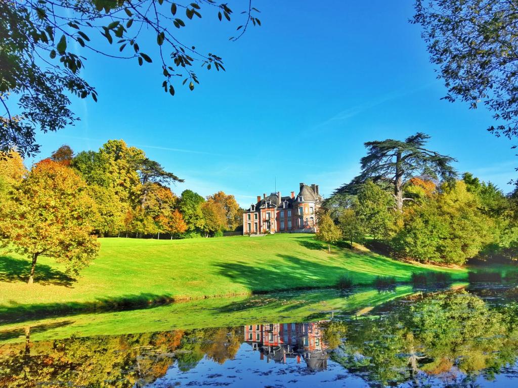 una grande casa su una collina vicino a un lago di Château de Chantore a Bacilly