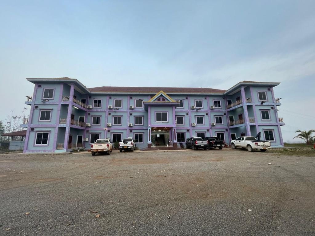 a large purple building with cars parked in front of it at khounxub view hotel in Ban Pho Touane