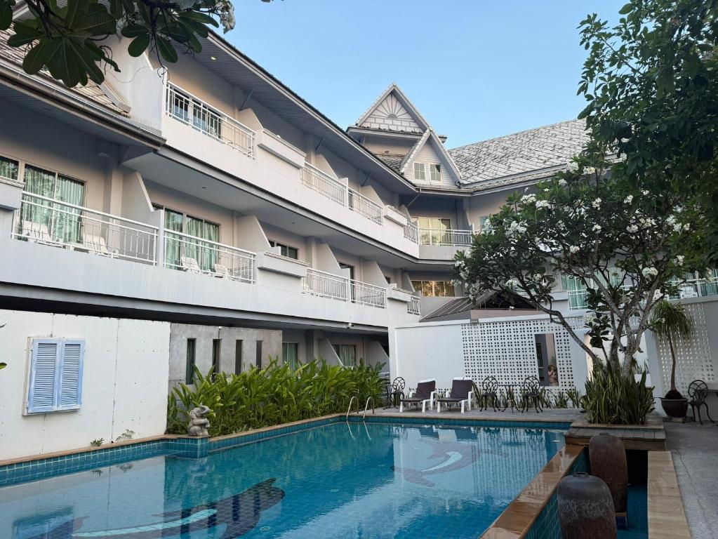 a hotel with a swimming pool in front of a building at Baan Suksiri Hotel Hua Hin in Hua Hin