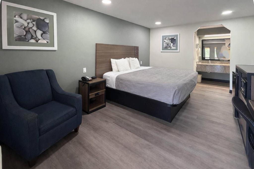 a hotel room with a bed and a chair at Quality Inn Mt Pleasant in Mount Pleasant