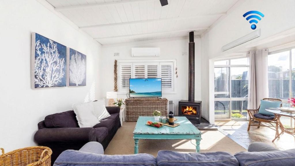 a living room with a couch and a table at Beach Bungalow in Corlette