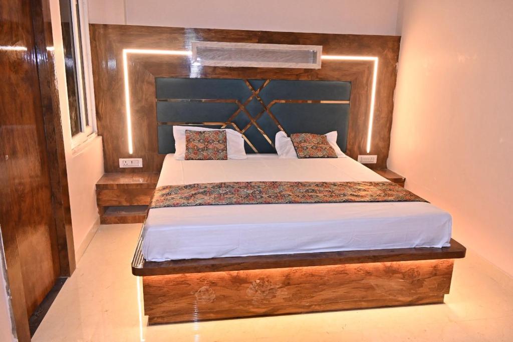 a bedroom with a bed with a wooden headboard at HOMESTAY KT palace in Varanasi