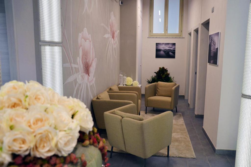 uma área de espera com cadeiras e flores numa sala de espera em Hotel Sant'Anna em Turim
