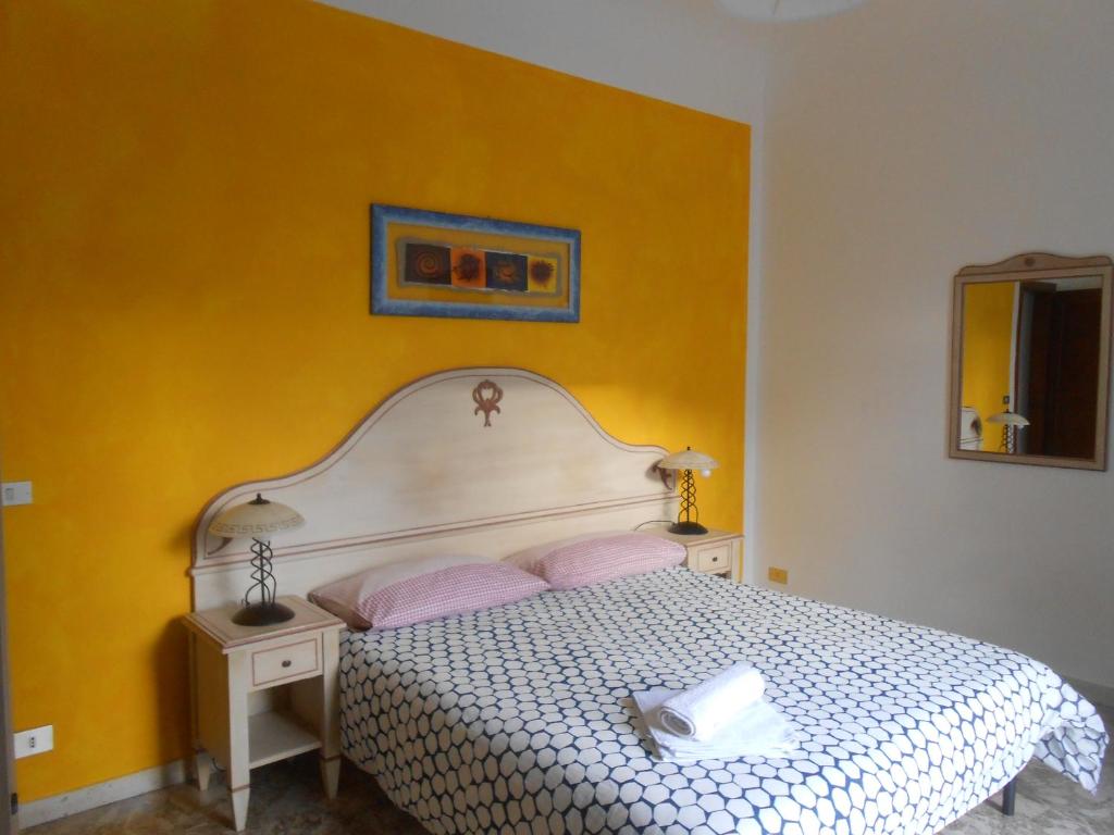 1 dormitorio con cama blanca y pared amarilla en Scala Apartment, en Florencia
