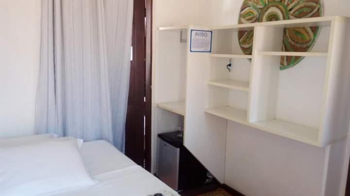 a bedroom with white shelves and a bed in it at Mirante do Forte in Praia do Forte