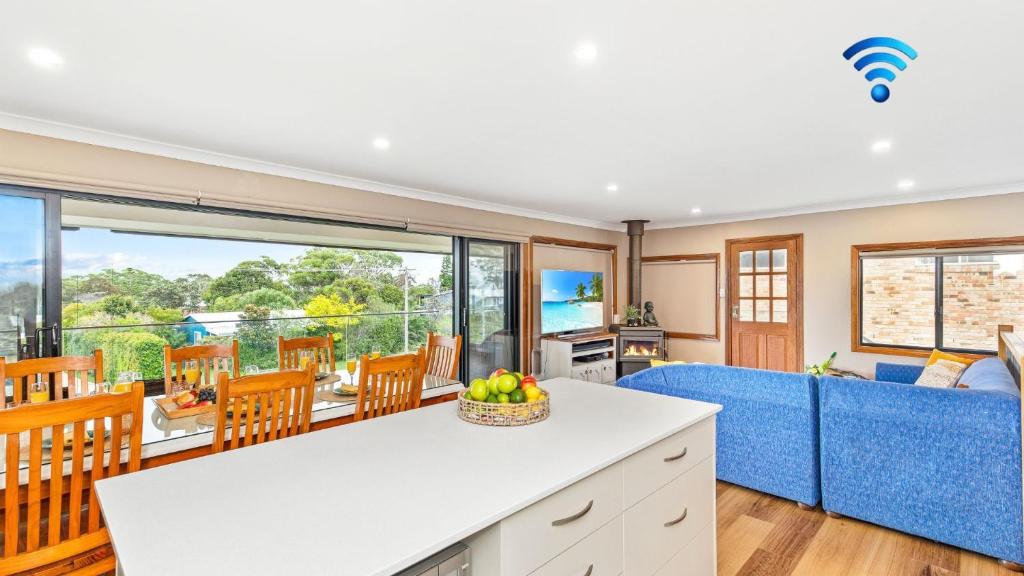 an open kitchen and living room with a blue couch at Tanapaser in Currarong