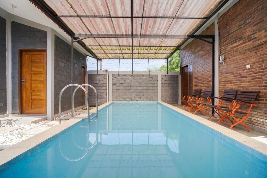 a swimming pool with two chairs and a swimming pool at Villa Maurine Prambanan in Jogonalan