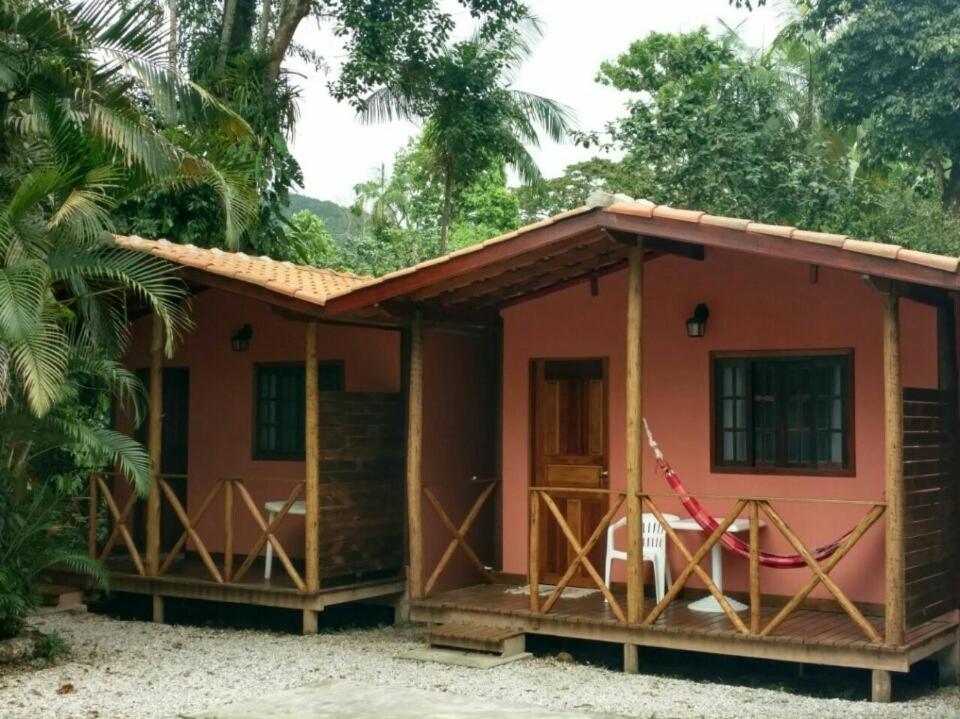 a small house with a pink at Chalés Bangalôs Itamambuca in Ubatuba
